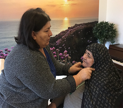 Muslimsk dame, hjælper en anden muslimsk dame, med at få tørlæde på